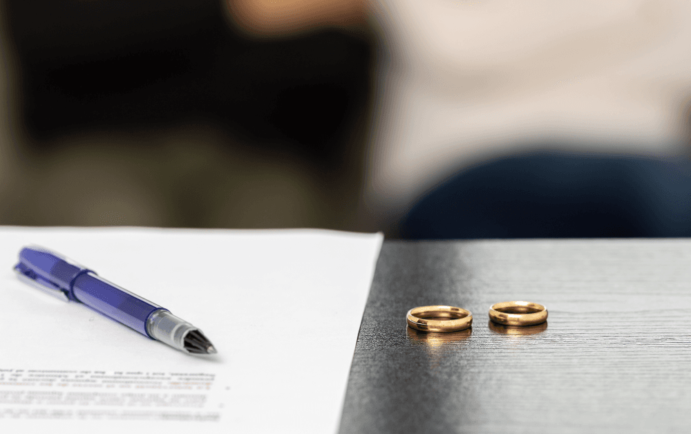 Piece of paper on a desk with two wedding rings on it