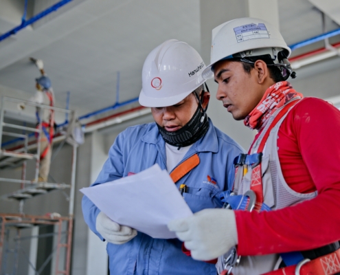 Two construction workers looking at a piece of paper