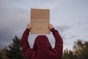 "Love shouldn't hurt" cardboard sign