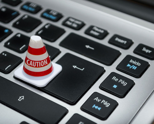 Miniature traffic cone with caution written on it, resting on a laptop keyboard - Data protection claims are on the rise.