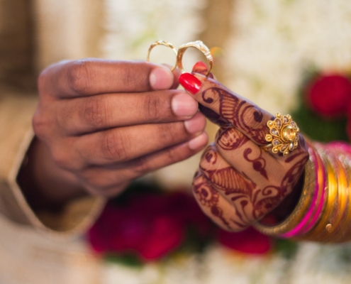 A person holding two wedding rings